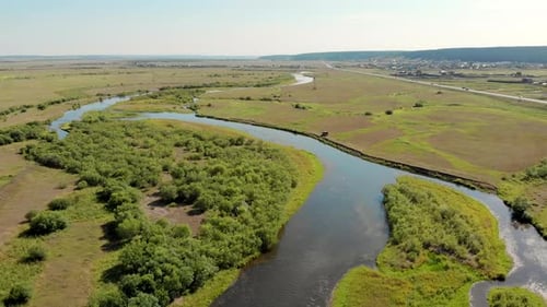 Waving River of Blue Colour Surrounded By Forests and Fields