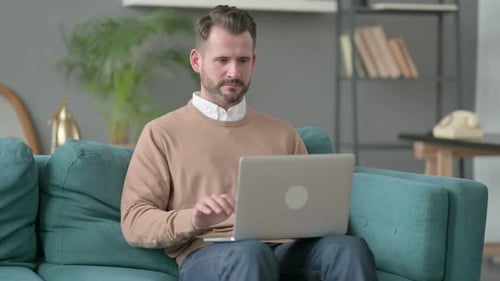 Man Frustrated with Laptop at Home on Couch