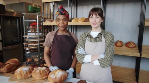 Smiling Women Stand in Front of Fresh Bread