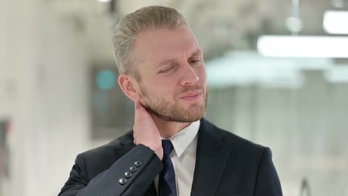 Man Massages Aching Neck in Business Suit