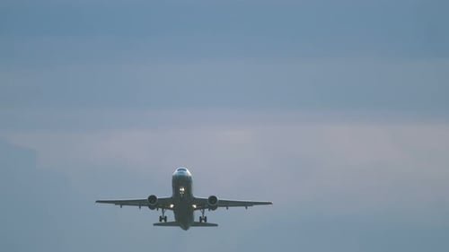 Airplane Takes Off from Airport Runway on Cloudy Day