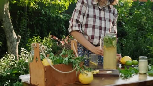 Person Preparing Lemonade in a Sunny Garden
