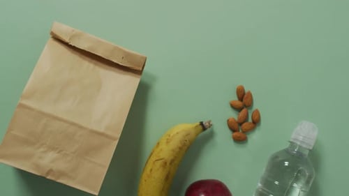 Animación de bolsa de almuerzo de papel y frutas sobre fondo azul