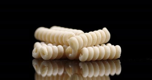 Close Up of Uncooked Rotini Pasta on Black