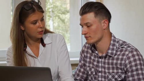 Young Man and Woman Looking at Laptop