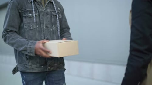 Courier Hands Package to Person Outdoors