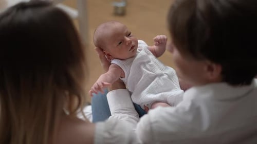 Portrait d'un adorable nouveau-né avec un couple de parents à la maison dans le salon