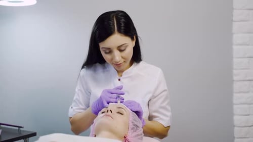 A woman on the procedure of injections in a cosmetology clinic. Preventing wrinkles.