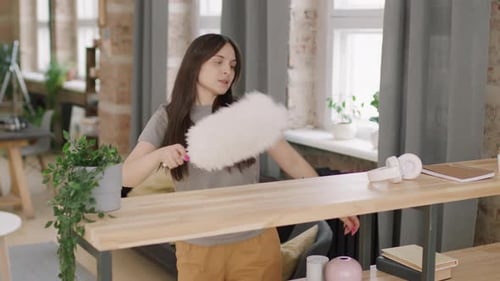 Woman Dancing with Duster in Modern Apartment