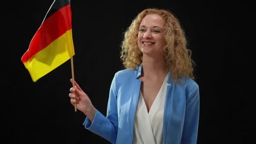 Porträt eines charmanten selbstbewussten Politikers mit deutscher Flagge, der sich in der Kamera umschaut