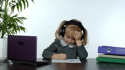 Child Drawing with Headphones at Desk