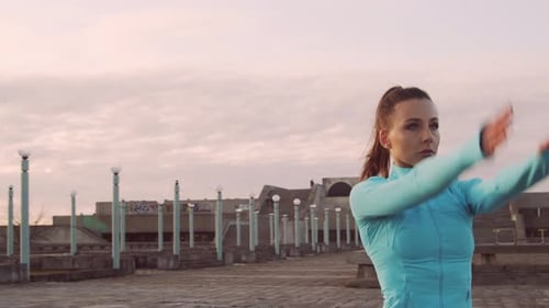 Woman Exercising on Rooftop at Sunrise