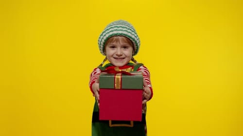 Joyful Child Offers Christmas Present Dressed as Elf