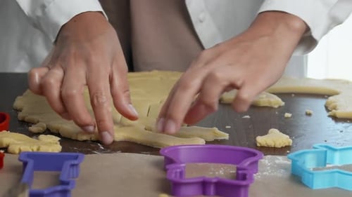 Hands Using Cookie Cutters on Dough