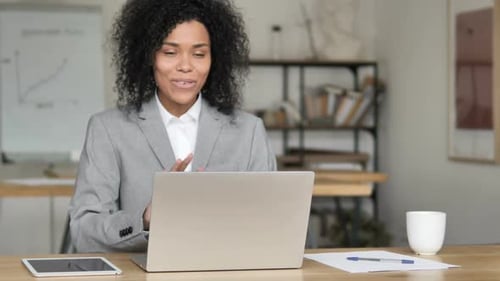 Woman Working on Laptop During Video Conference in Office