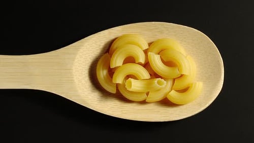 Macaroni Pasta Poured onto a Wooden Spoon