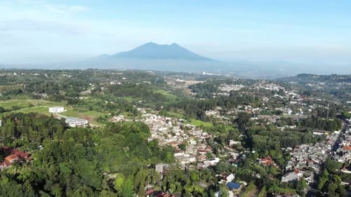 Cinematic aerial view of suburban area with a beautiful mountain in the back and clear blue sky in t