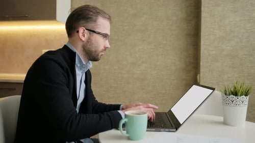 Focused Young Adult Working at Laptop with Coffee