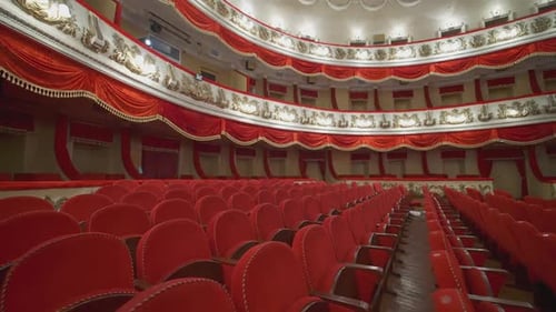 Rows of red chairs in theater hall. Beautiful empty opera house without audience at lockdown time.
