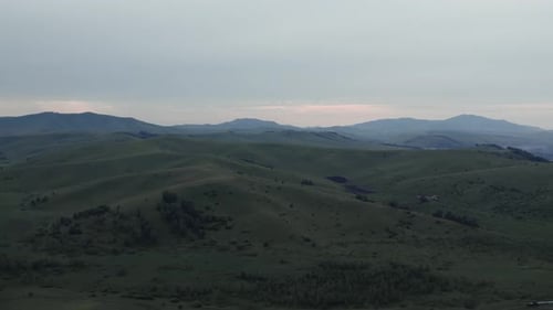 Aerial view from a drone on valley and mountains under blue sky with clouds