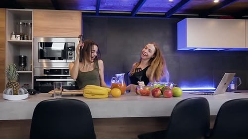 Two Women Dancing and Singing in Kitchen