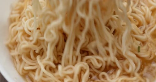 Close up Noodles Being Stirred with Chopsticks