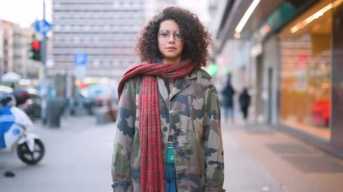 Smiling Woman with Curly Hair on City Street