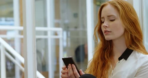 Female executive using mobile phone in office 4k