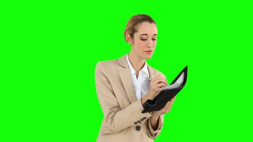 Woman in Business Suit Writing in Notebook