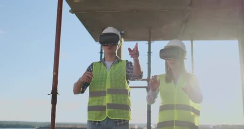 Waist Up Portrait of Two Modern Construction Workers Using VR Gear to Visualize Projects on Site
