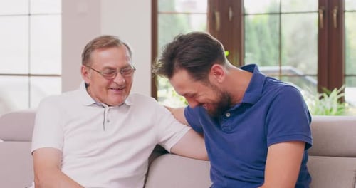Feliz familia masculina de dos generaciones padre maduro mayor e hijo adulto joven sonriente