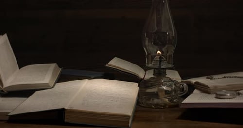 Antique Lamp Illuminating Books on a Table