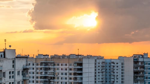 Running Clouds Over City During Sunset