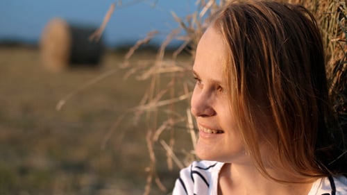 Smiling Woman By The Hay Roll In Field