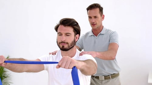 Man Using Resistance Band with Trainer