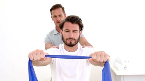 Man Stretching Resistance Band with Therapist Massage