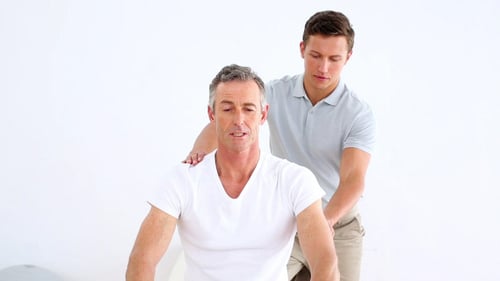 Physical Therapist Assists Man with Resistance Band