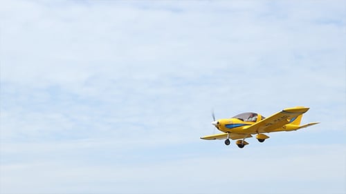 Yellow Airplane Flying in a Blue Sky