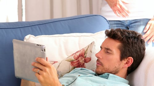 Loving Couple Embracing on Sofa with Tablet