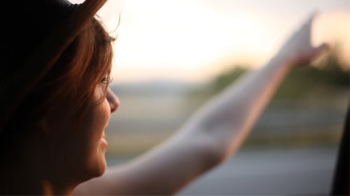 Woman Enjoys Golden Hour Car Ride in Countryside