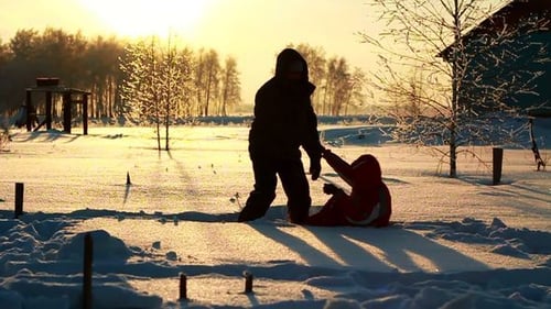 Playful Father Helping Child in Winter Snow