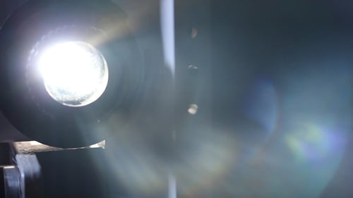 Vintage Film Projector with Bright Light in Dark Room