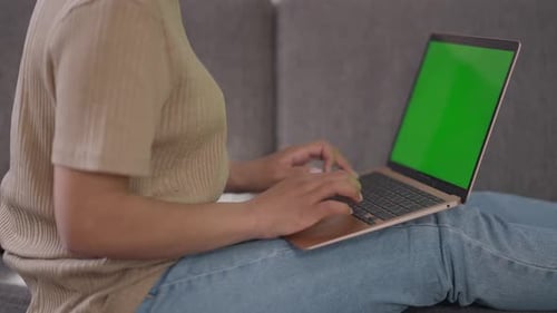 Side View of Unrecognizable African American Woman Typing on Laptop Keyboard with Green Screen