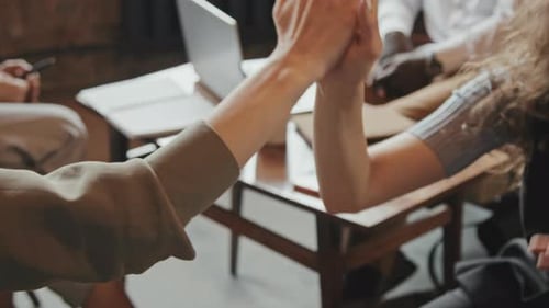 Close-Up of Coworkers Giving High-Fives