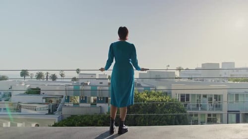 Stylish Woman Overlooking Sunny Coastal City Rooftop