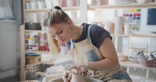Woman working with clay on a pottery wheel