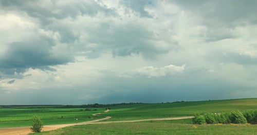 Scenic Green Fields Under Cloudy Sky