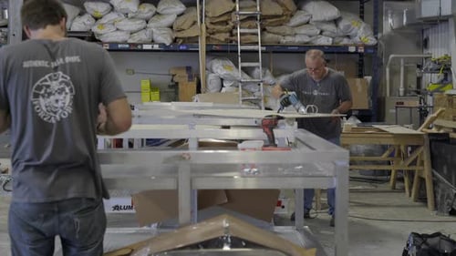 Two workers manufacturing pizza oven in workshop