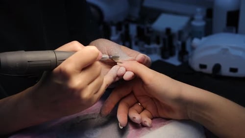 Nail Technician Shaping Fingernails During a Manicure