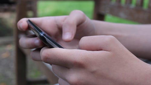 Hands Using Cell Phone Outdoors